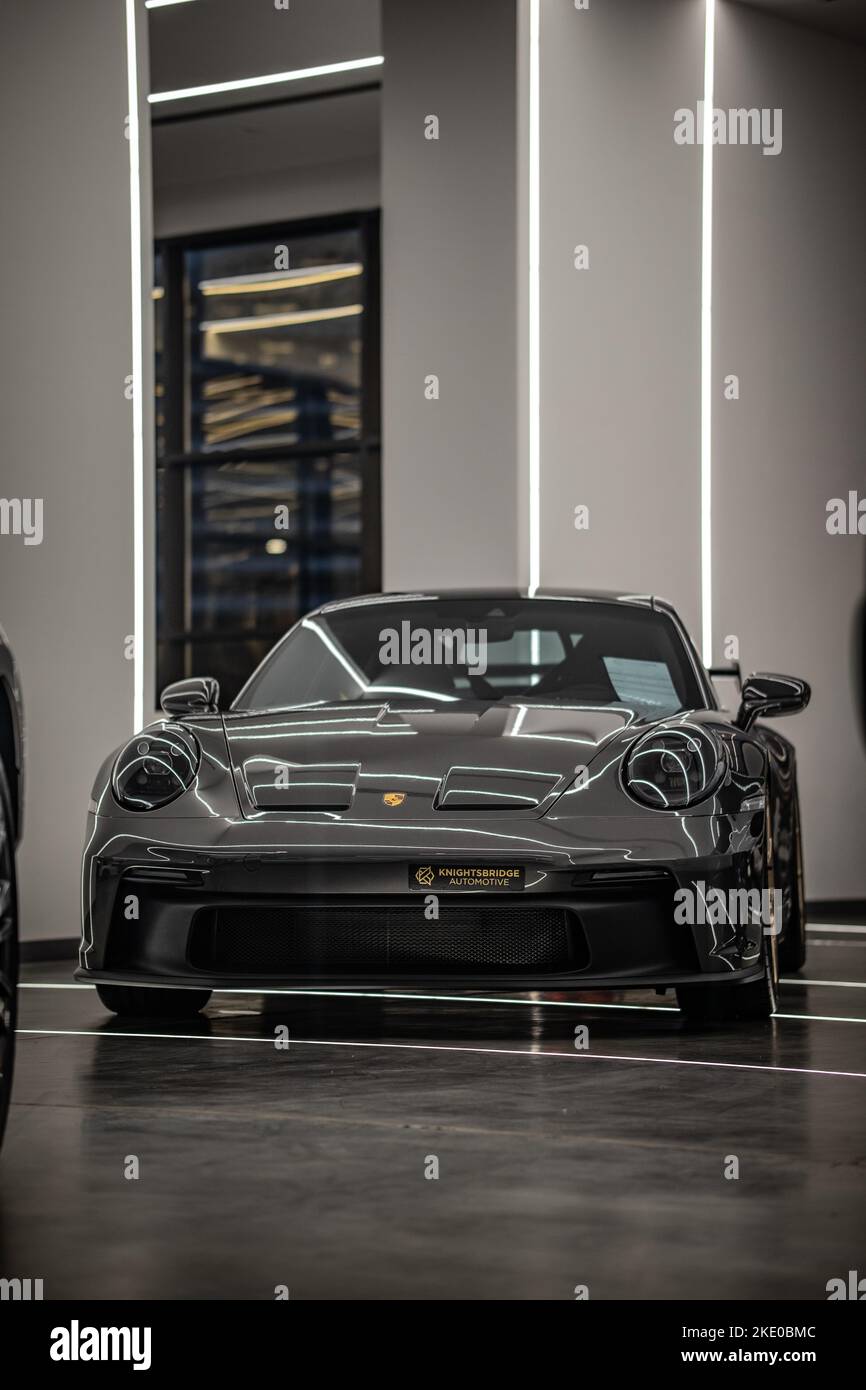 A vertical of a grey Porsche 911 car in a car salon in Doha, Qatar