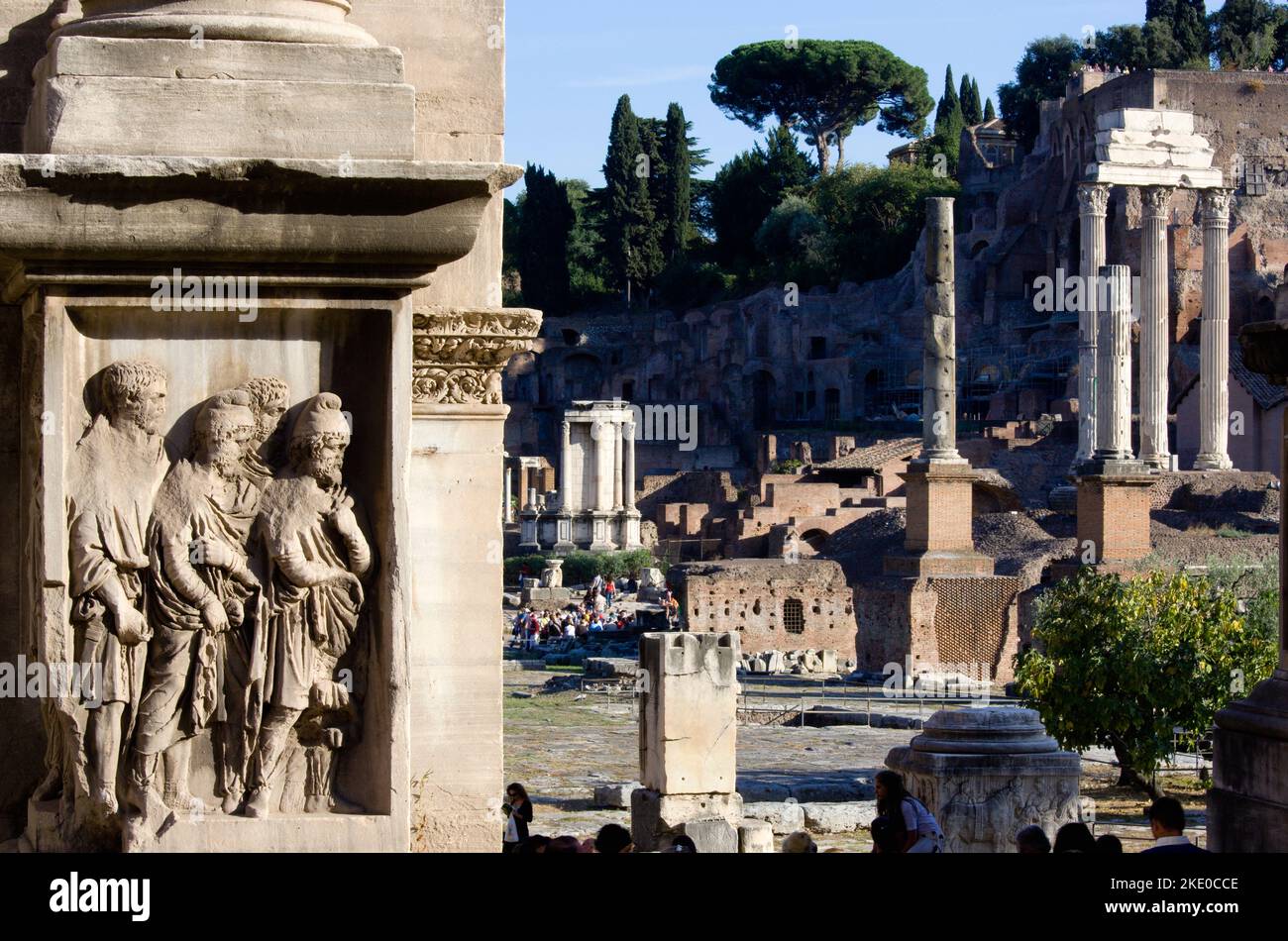 ITALY Lazio Rome The floor of the Forum with tourists. A detail of the Arch of Septimius Severus the Temple of Vesta and the three Corinthian columns of the Temple of Castor and Pollux in front of the Palatine hill Stock Photo
