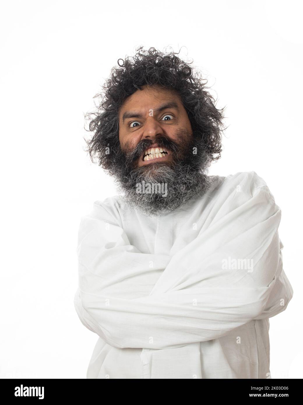 A vertical shot of a male psychopath grinding teeth with a weird facial expression in a straitjacket Stock Photo