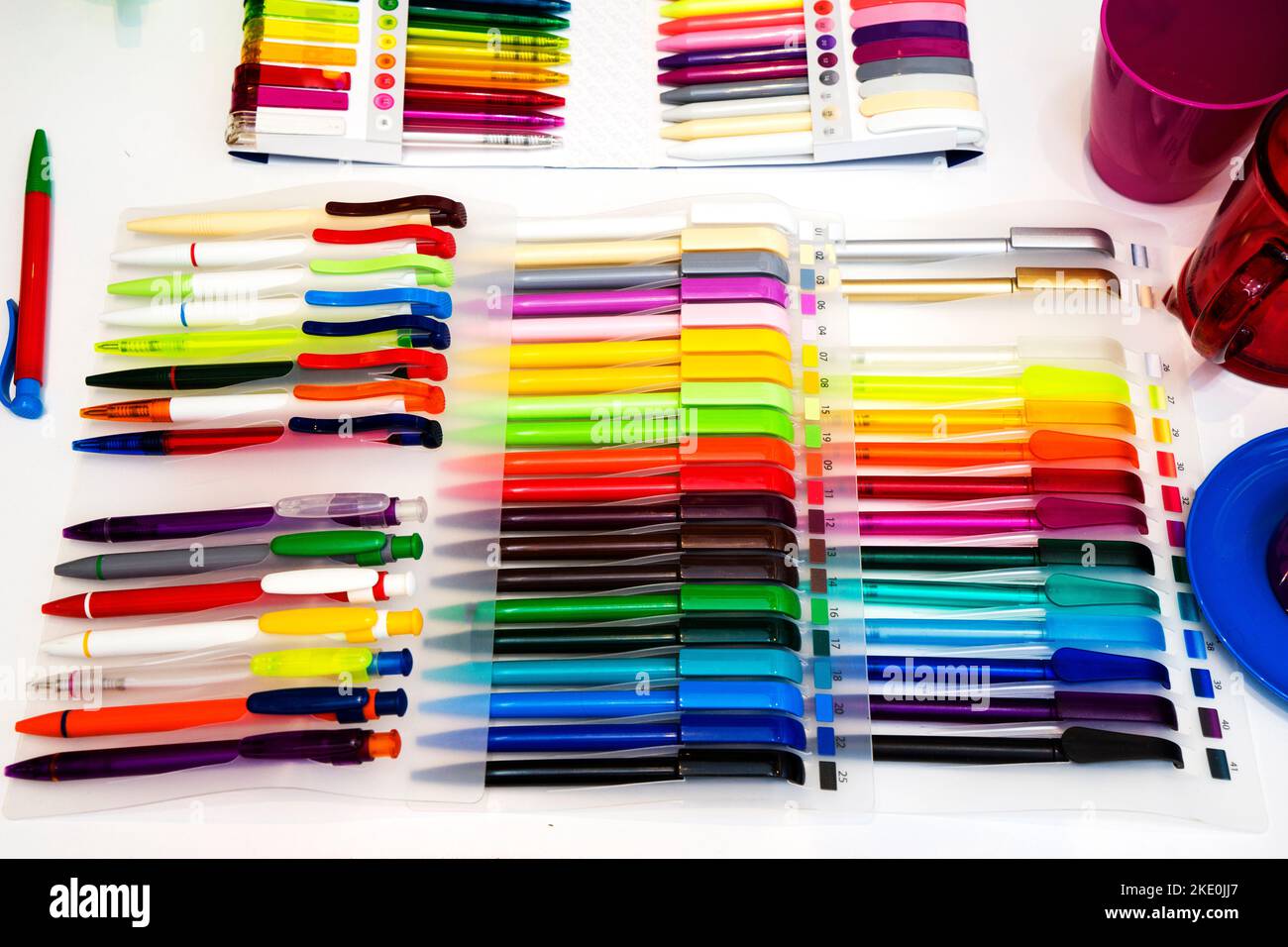 a group multi-colored plastic ballpoint pens on white table Stock Photo ...