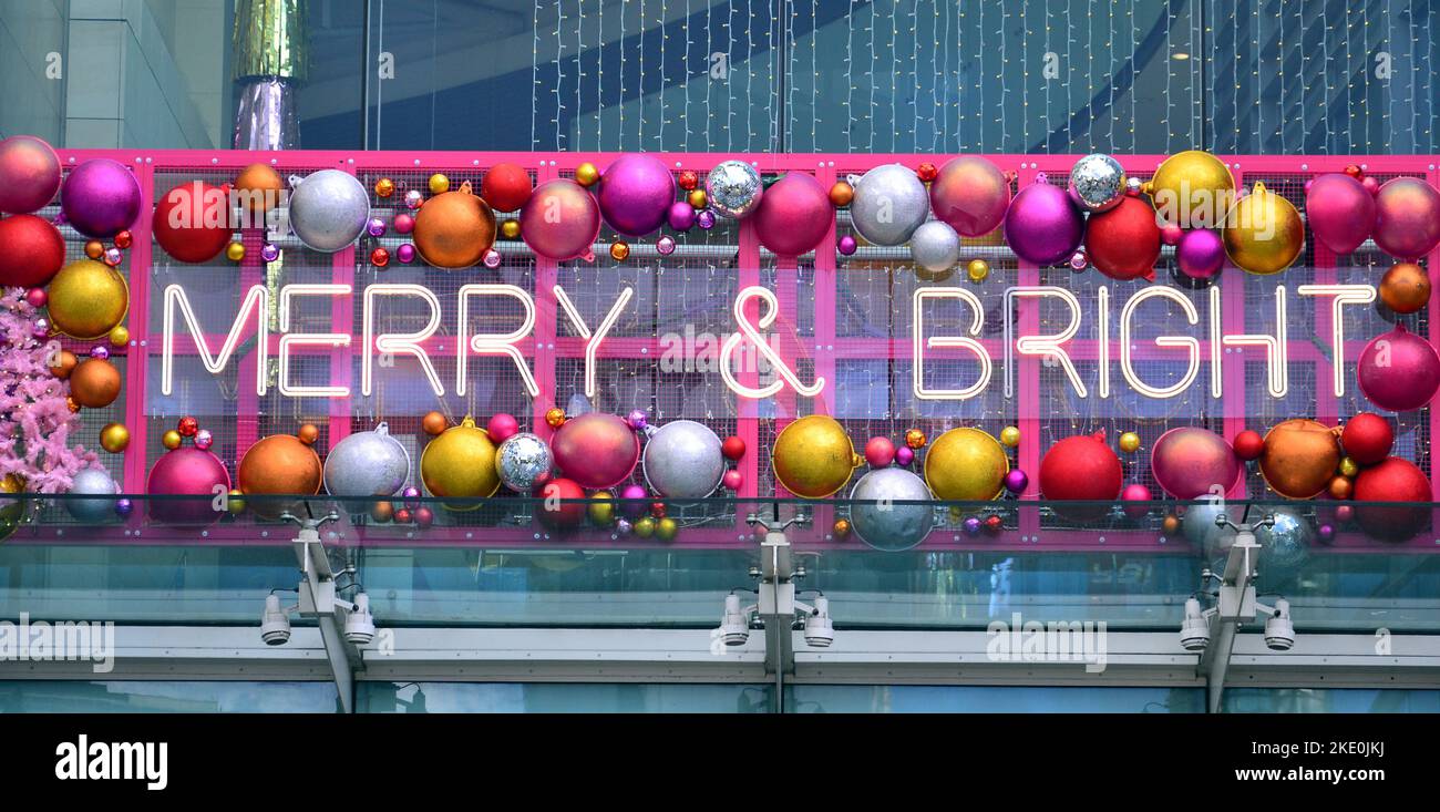 Exterior sign says Merry & Bright with Christmas or Xmas decorations on the Arndale shopping centre in central Manchester, UK Stock Photo