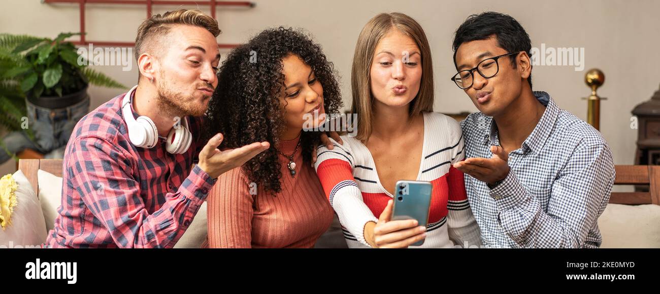 Horizontal banner or header with young guys group sending kisses during a video call with friends - Community concept with multi ethnic friends having Stock Photo