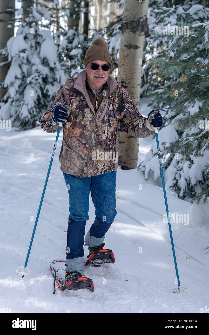 A middle-aged man wearing snowshoes competes in the Annual Chama Chile Ski Classic in the Southern San Juan Mountains near Chama, New Mexico, USA. Stock Photo