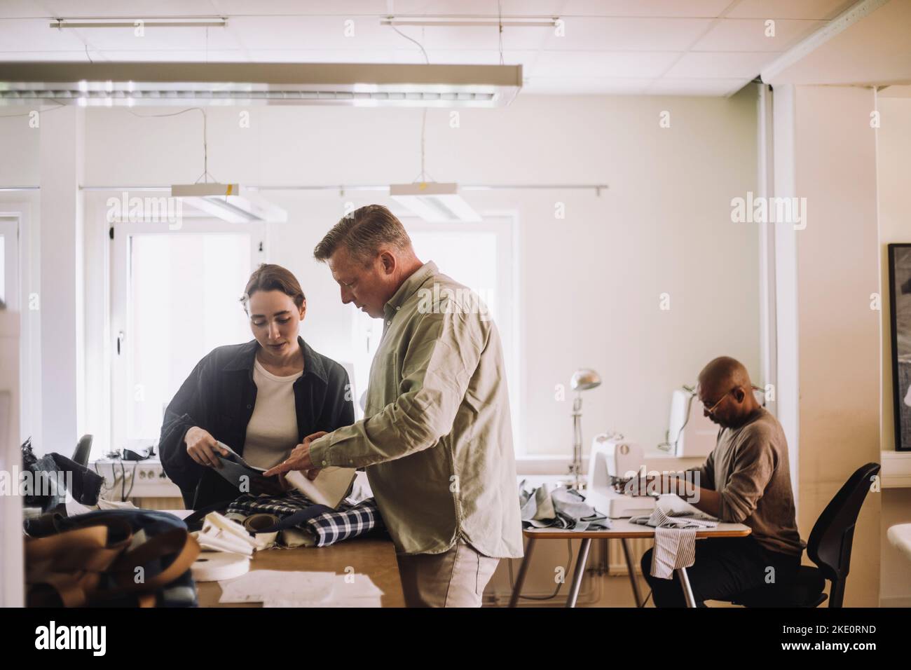 Design professionals discussing together while working in workshop Stock Photo