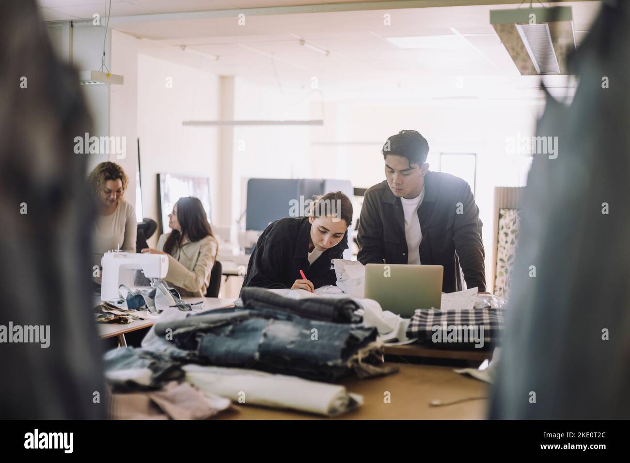 Multiracial male and female design professionals working on laptop at ...