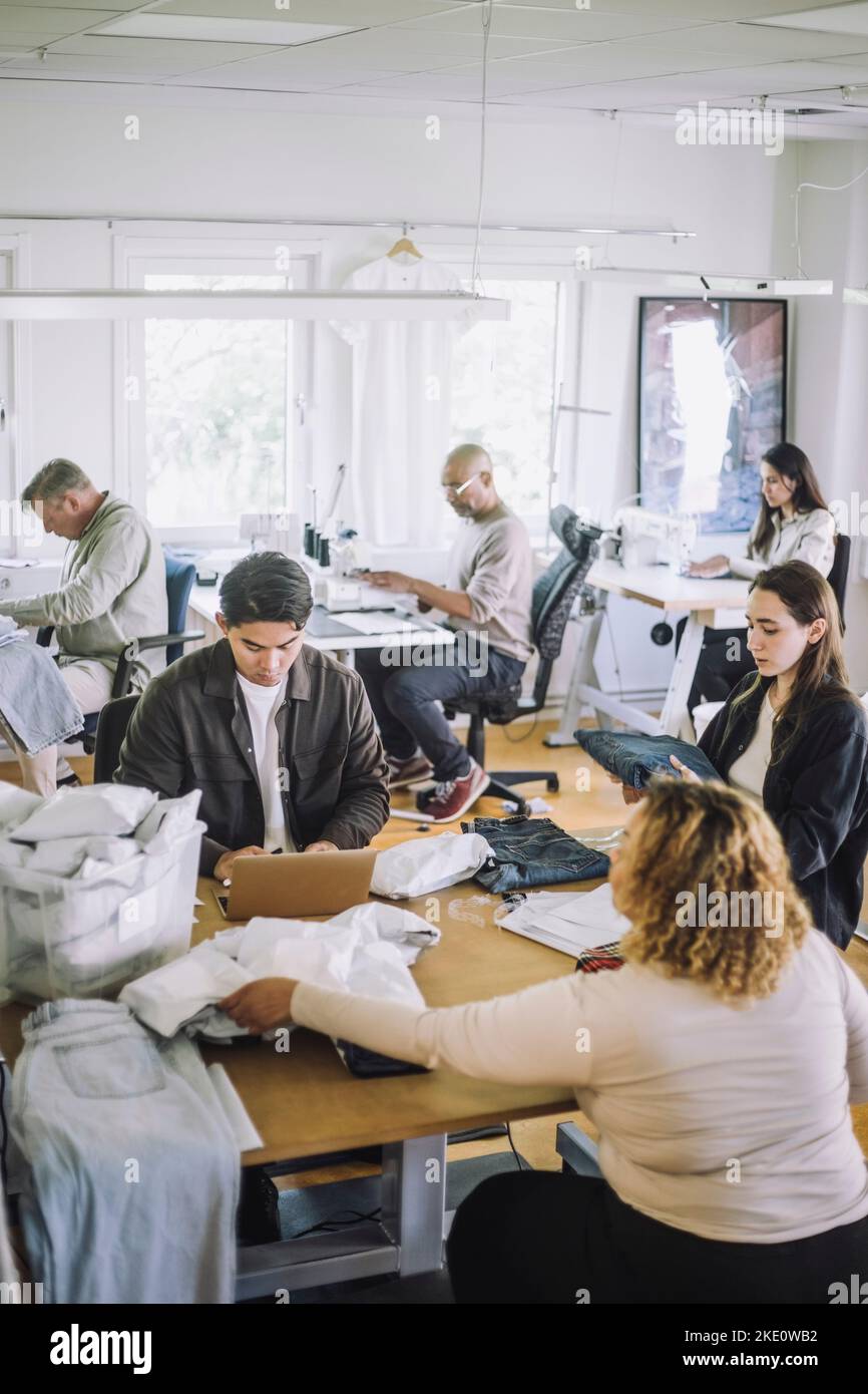 Multiracial male and female fashion designers working together at