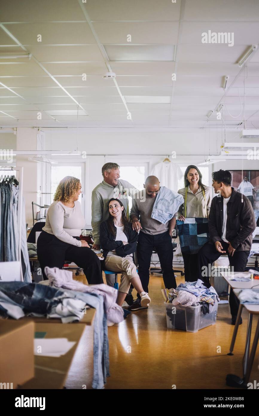 Happy male and female fashion designers enjoying at Stock