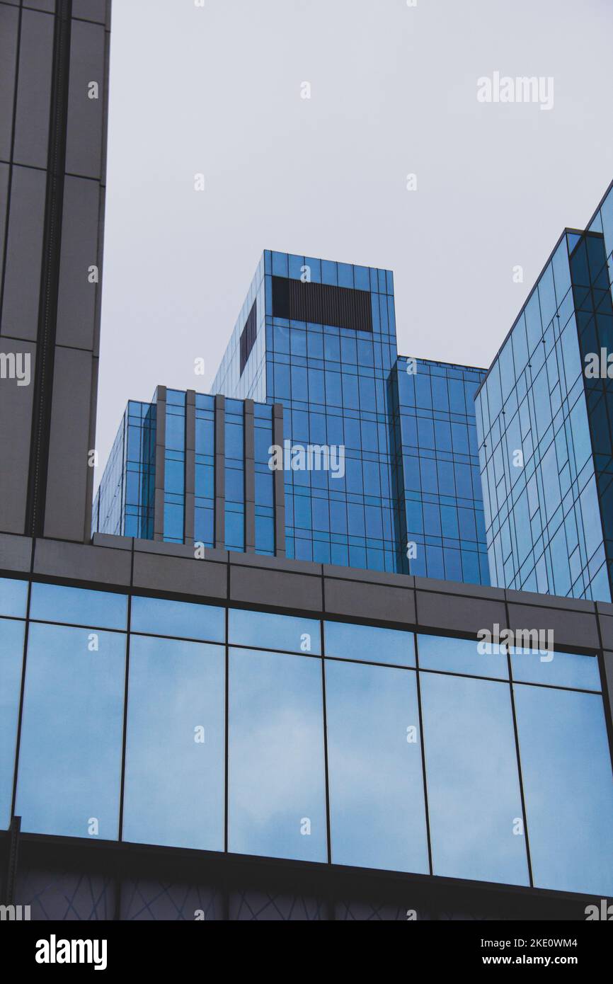 A Low angle of modern skyscrapers against a blue sky Stock Photo - Alamy