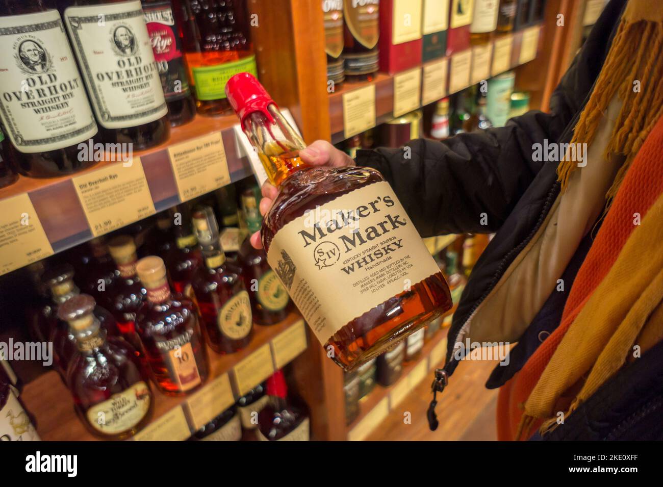 A consumer prepares to purchase a bottle of Maker's Mark bourbon in a liquor store in New York on Tuesday, January 14, 2014.  The Japanese company Suntory Holdings has proposed the purchase of Beam Inc., the maker of Jim Beam, Maker's Mark and other liquors, for $16 billion.  Suntory is one of Japan's largest brewers and the purchase, if approved,  would make the company the third largest liquor produce behind Diageo and Pernod Ricard. (© Richard B. Levine) Stock Photo