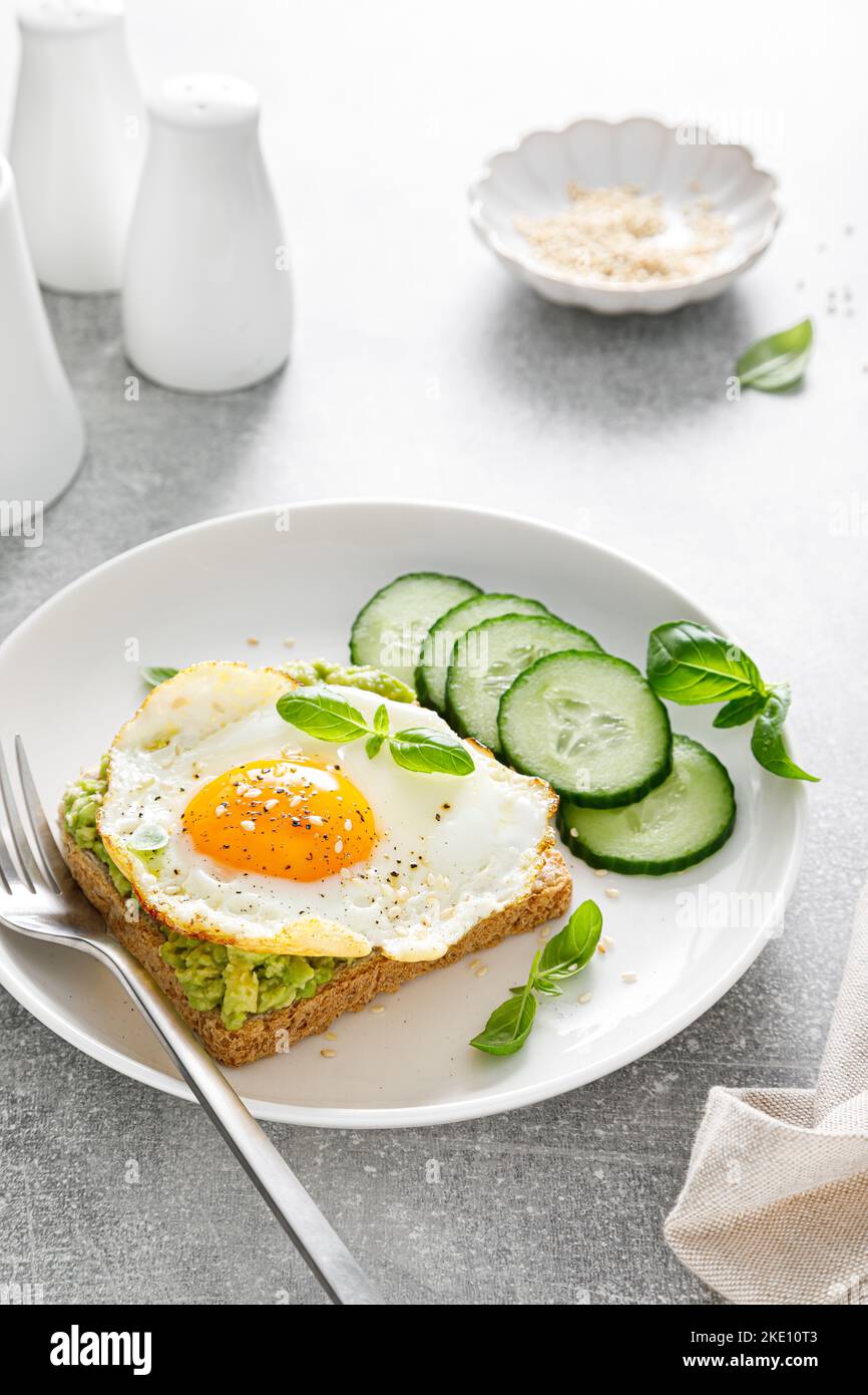 Avocado toast with fried egg for breakfast, healthy food Stock Photo