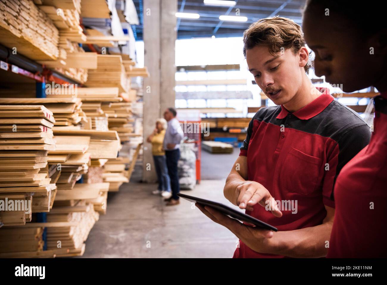 Salesman explaining female staff over digital tablet at hardware store Stock Photo