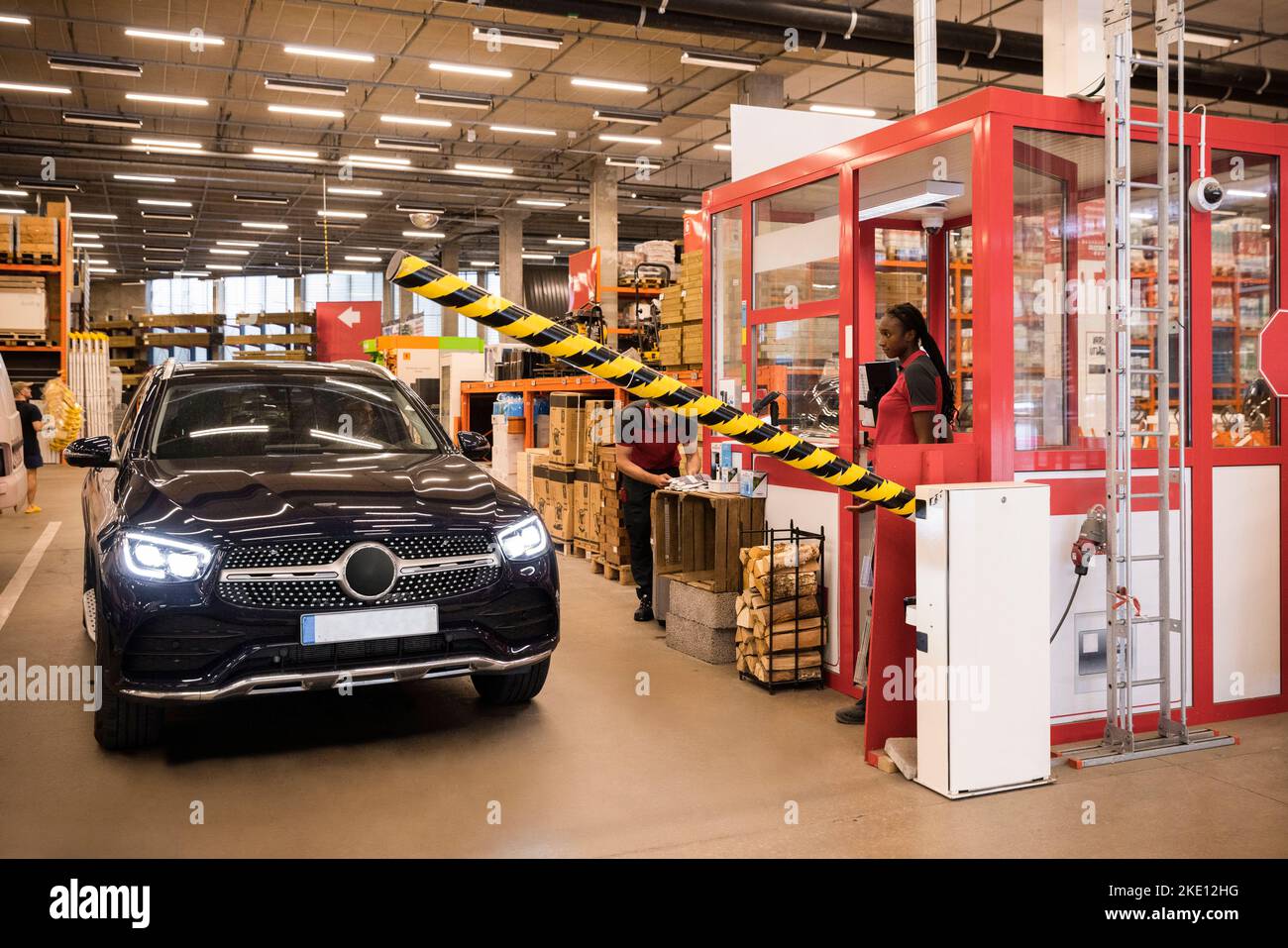 Sales staff opening barricade for customer car at warehouse Stock Photo