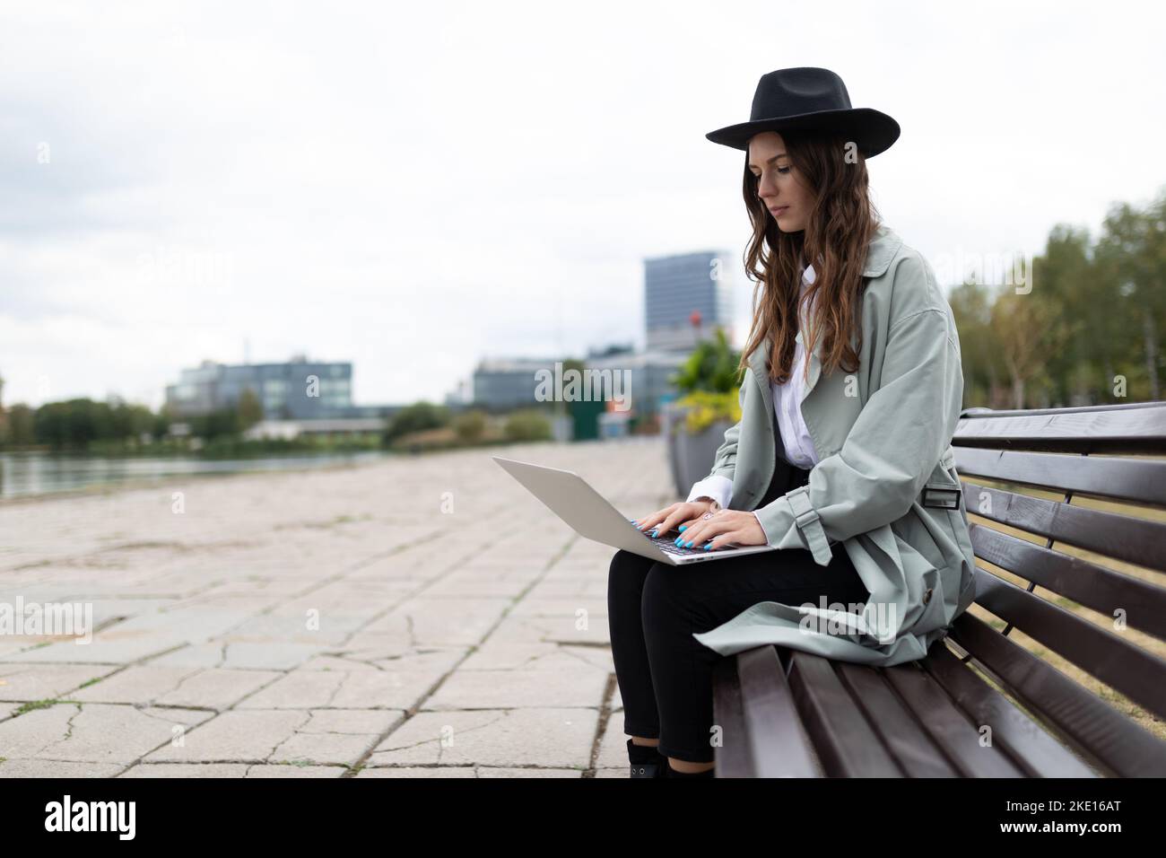 young strong woman freelancer software developer working on laptop outside Stock Photo