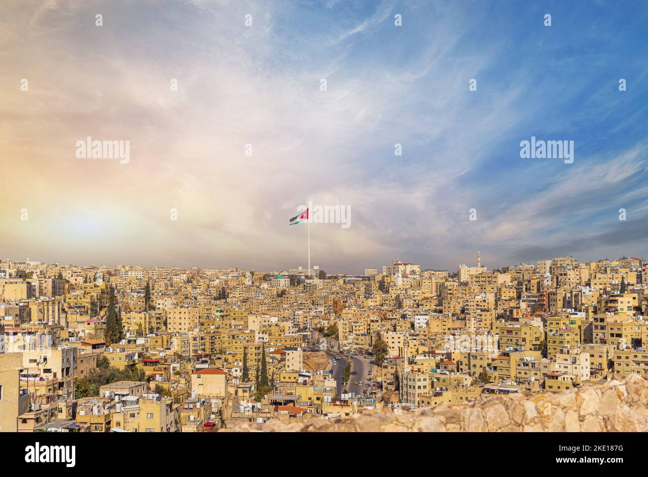 Jordan flag in Amman, panoramic view of cloudy sky background Stock