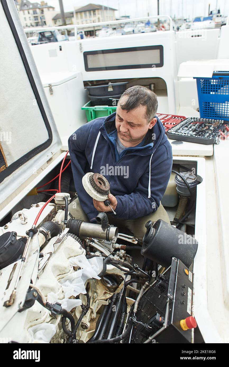 Boat mechanic repairing a ship engine Stock Photo Alamy