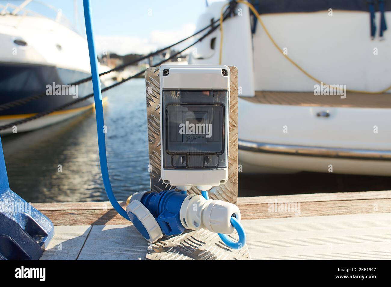 Electrical power socket bollard on pier. Charging station for boats in
