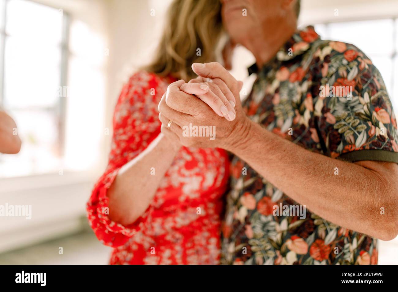 Senior couple holding hands while dancing together in class Stock Photo