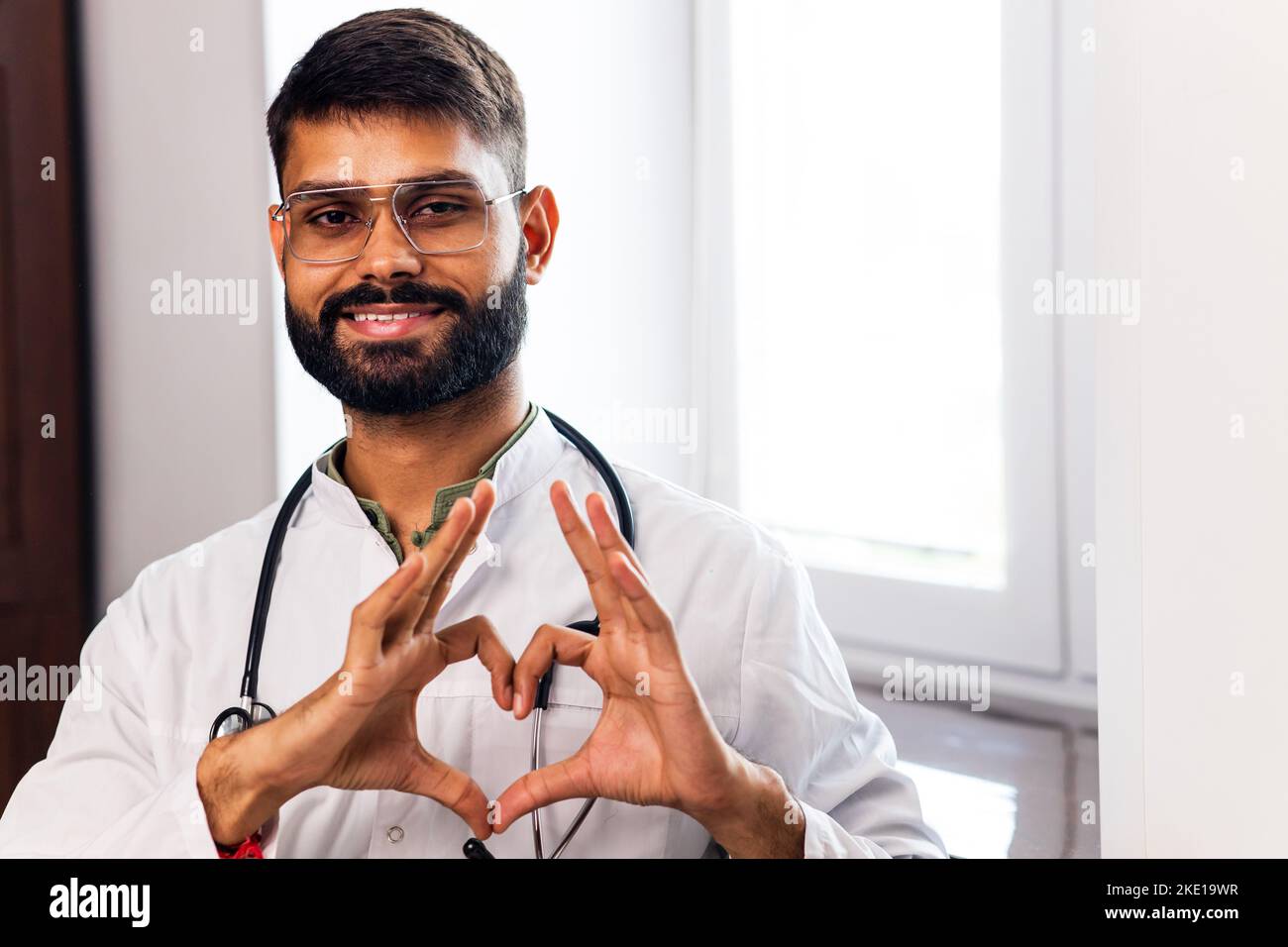 hispanic medical student in white coat with stethoscope in clinic Stock Photo