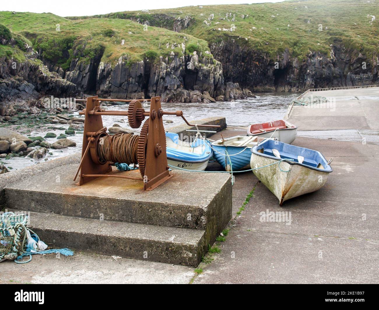 Rusty winch with fisherboats in Brandon Creek, Dingle Peninsula
