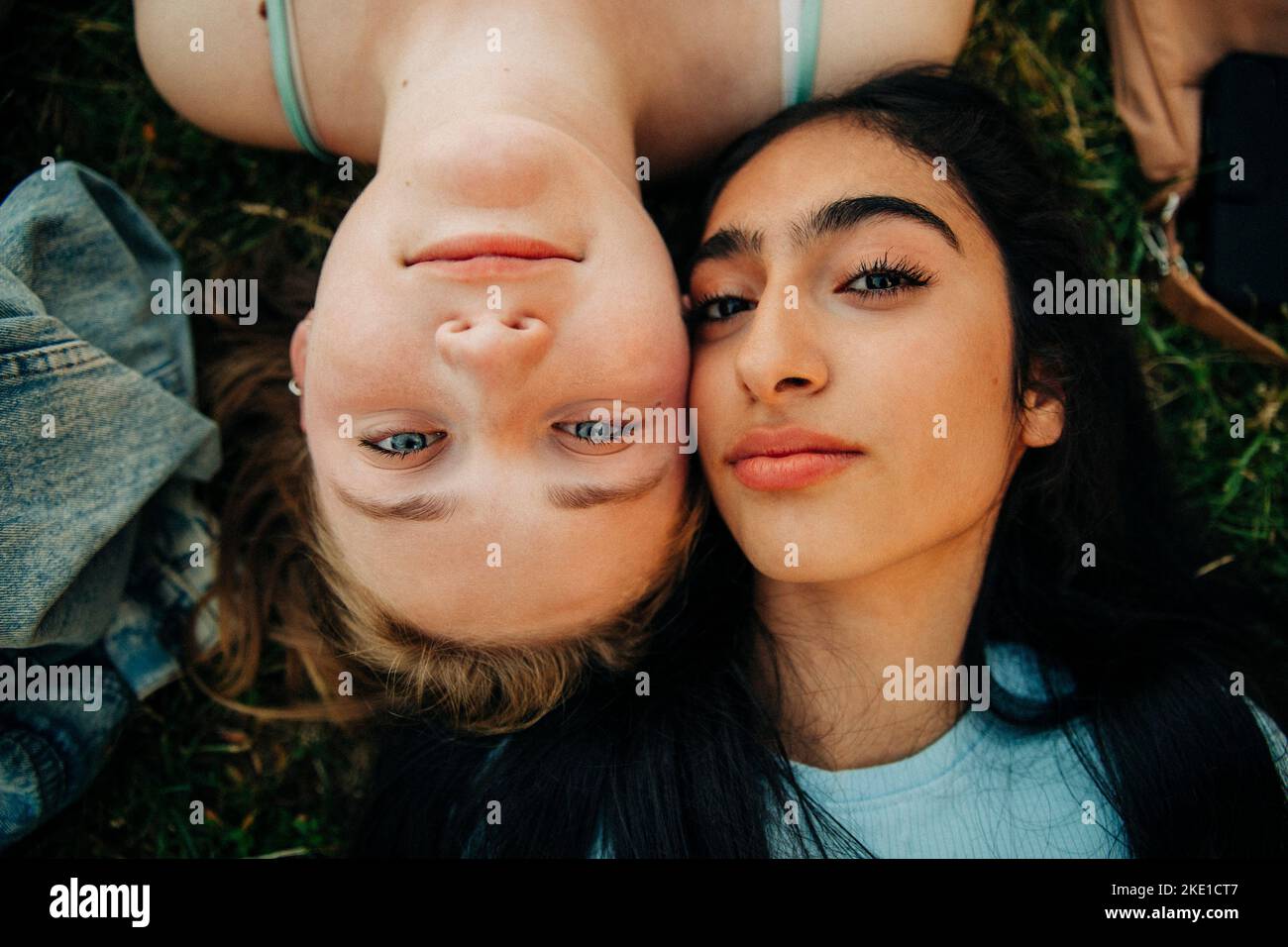 Teenage girls lying together at park Stock Photo