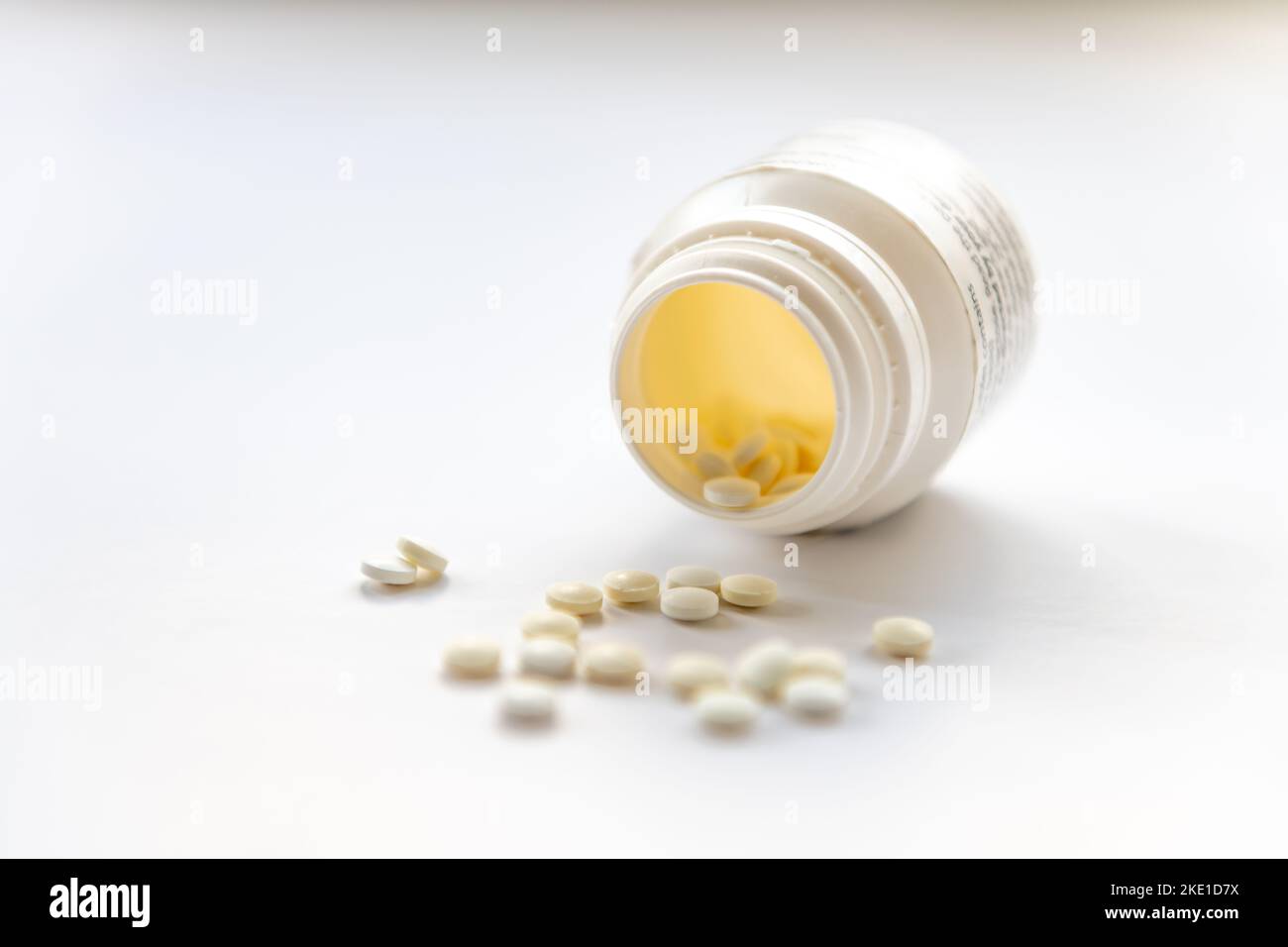A open bottle of pain killers tablets isolated in a white background