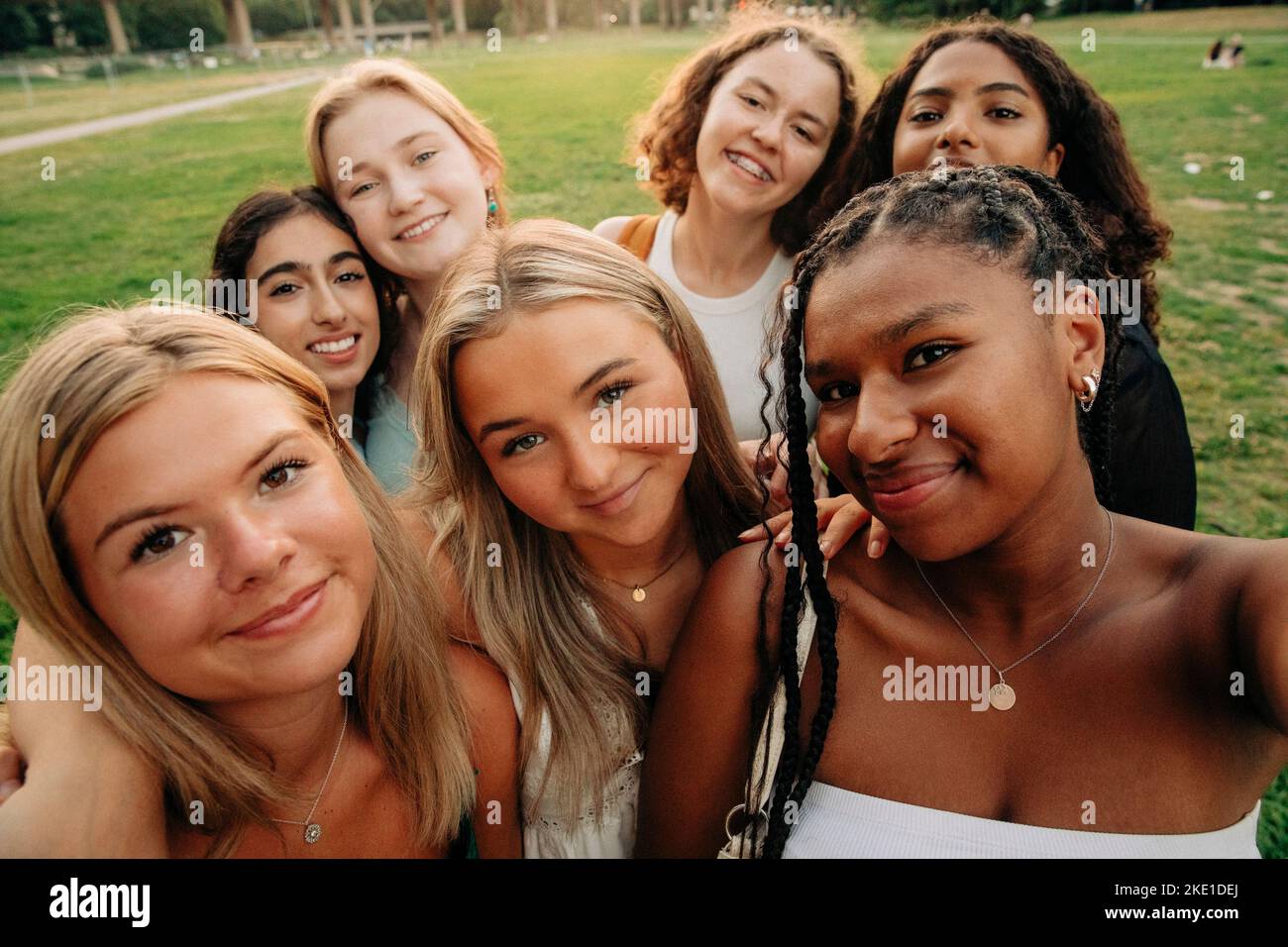 Smiling multiracial teenage girl taking selfie at park Stock Photo