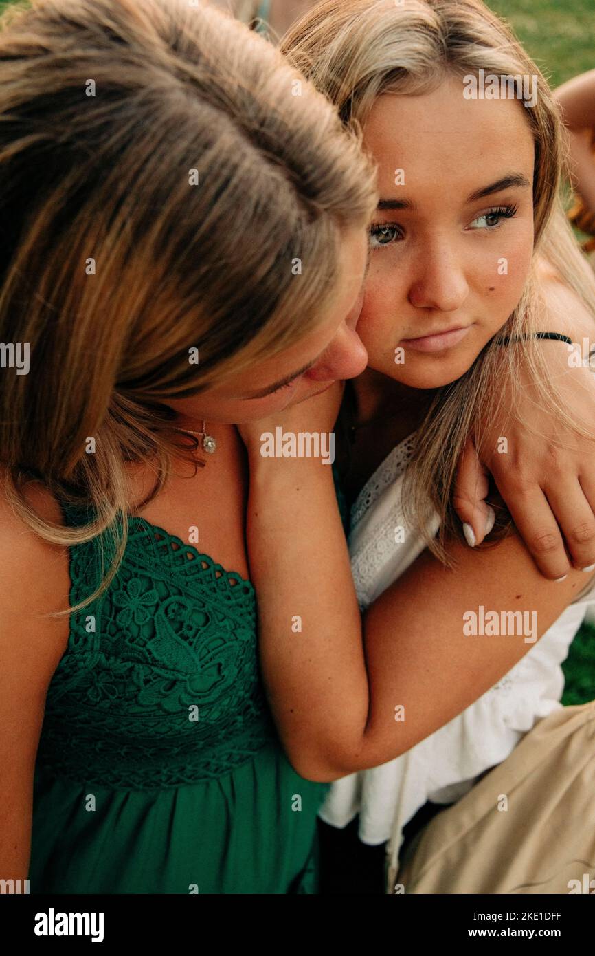 Teenage girl hugging female friend looking away Stock Photo
