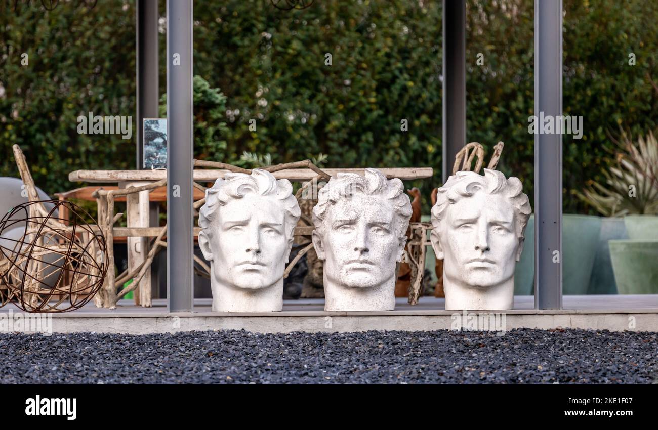 three oversized mens heads lined up in a row Stock Photo