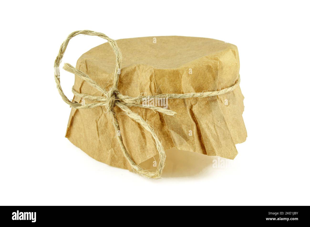 Glass jar paper cover with knotted rope isolated on white background