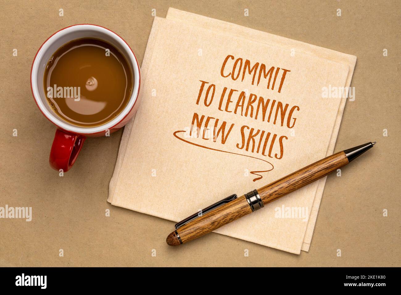 commit to learning new skills - motivational advice or reminder on a napkin with coffee, continuing education and personal development concept Stock Photo