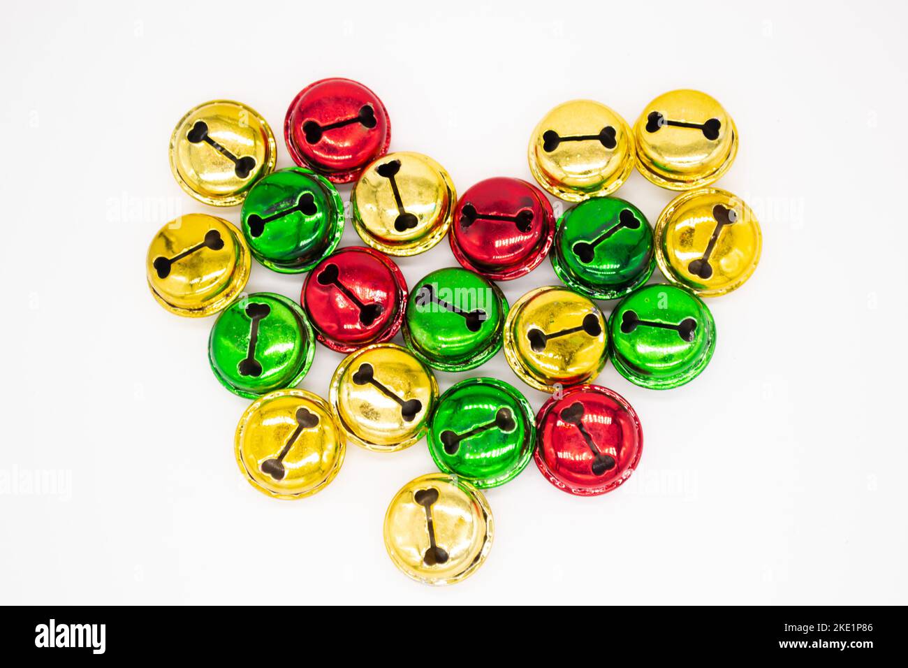 Colorful ringing Christmas bells in gold, red and green. In shape of heart. The concept of Christmas. Holiday background. Stock Photo