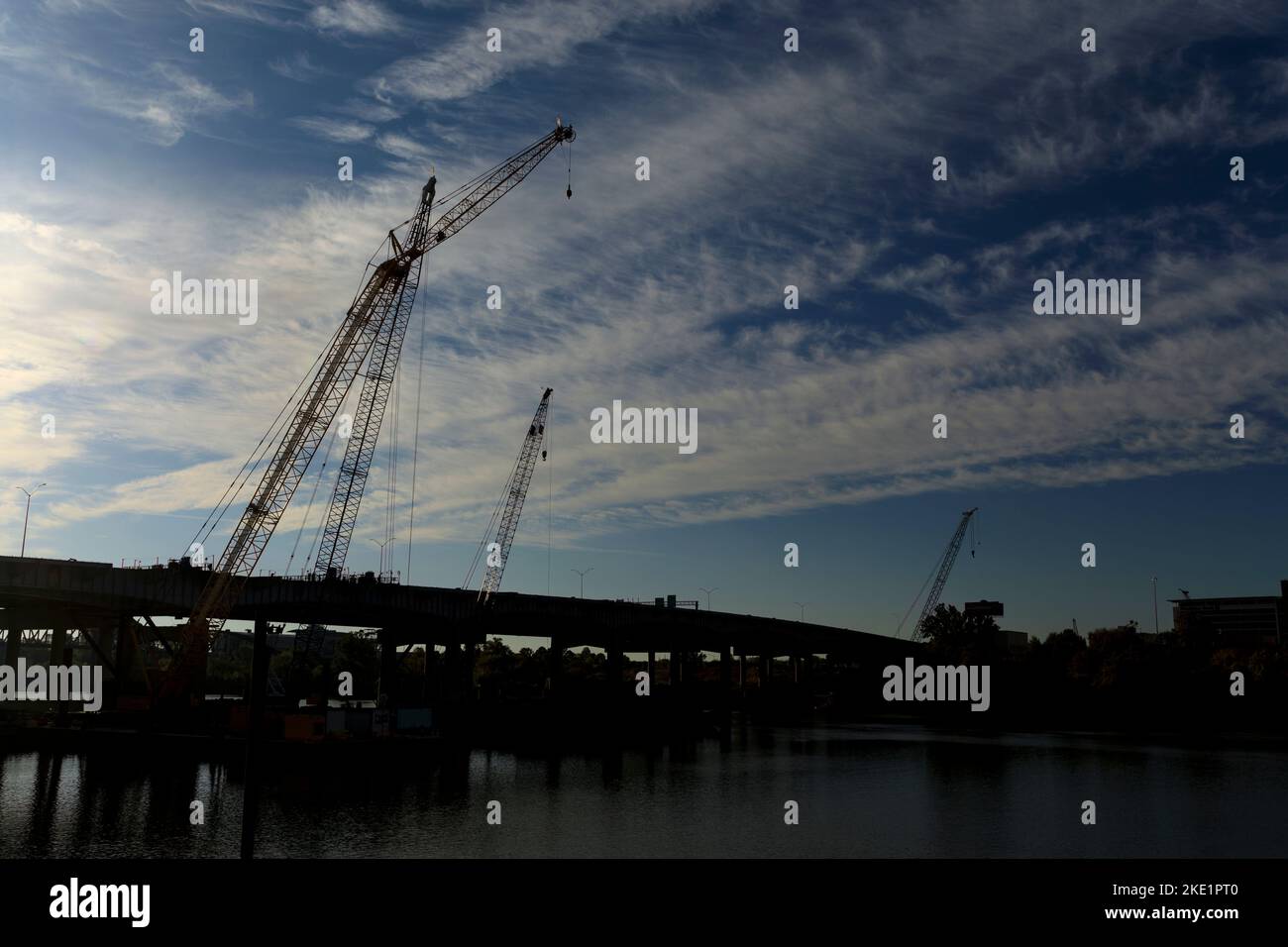 Silhouette of construction cranes working on the Arkansas River Bridge, Interstate 30, in