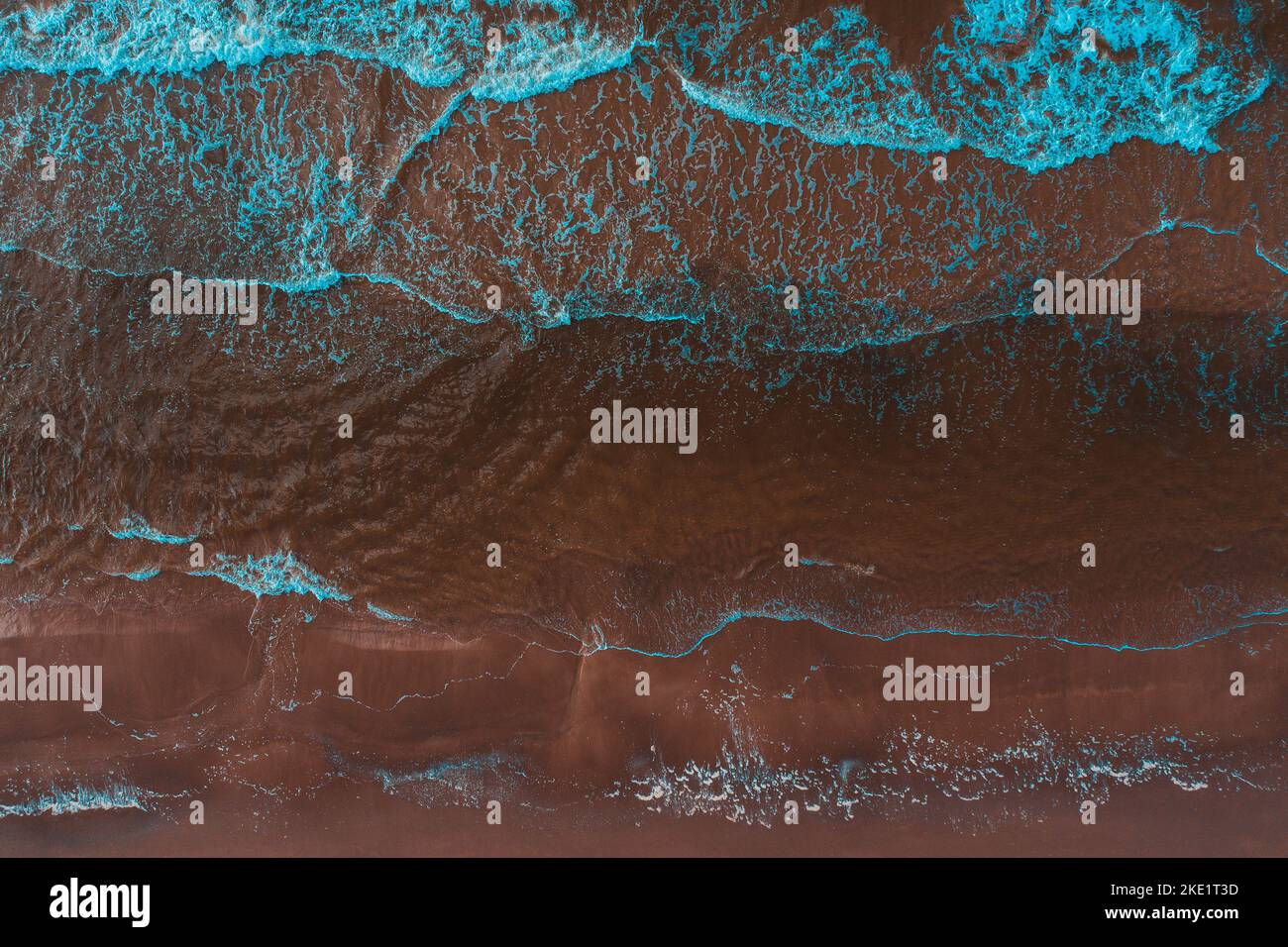 An aerial view of the sea waves and foam crashing on the seashore Stock ...