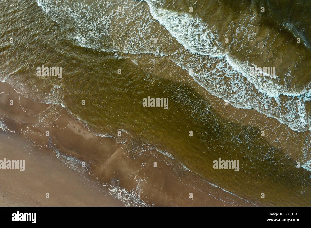 An aerial view of the sea waves and foam crashing on the seashore Stock ...