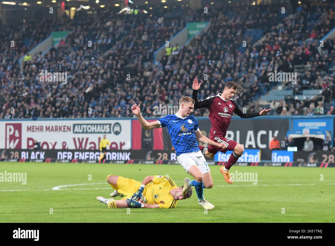 Rostock, Germany. 09th Nov, 2022. Soccer: 2. Bundesliga, Hansa Rostock - 1. FC Nürnberg, Matchday 16, Ostseestadion. Rostock's Svante Ingelsson and Nuremberg's Jamie Lawrence run over Nuremberg goalkeeper Christian Mathenia. Credit: Gregor Fischer/dpa - IMPORTANT NOTE: In accordance with the requirements of the DFL Deutsche Fußball Liga and the DFB Deutscher Fußball-Bund, it is prohibited to use or have used photographs taken in the stadium and/or of the match in the form of sequence pictures and/or video-like photo series./dpa/Alamy Live News Stock Photo