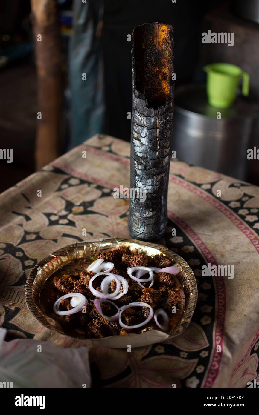 chicken is being cooked inside the bamboo canes.this is called bamboo chicken Stock Photo