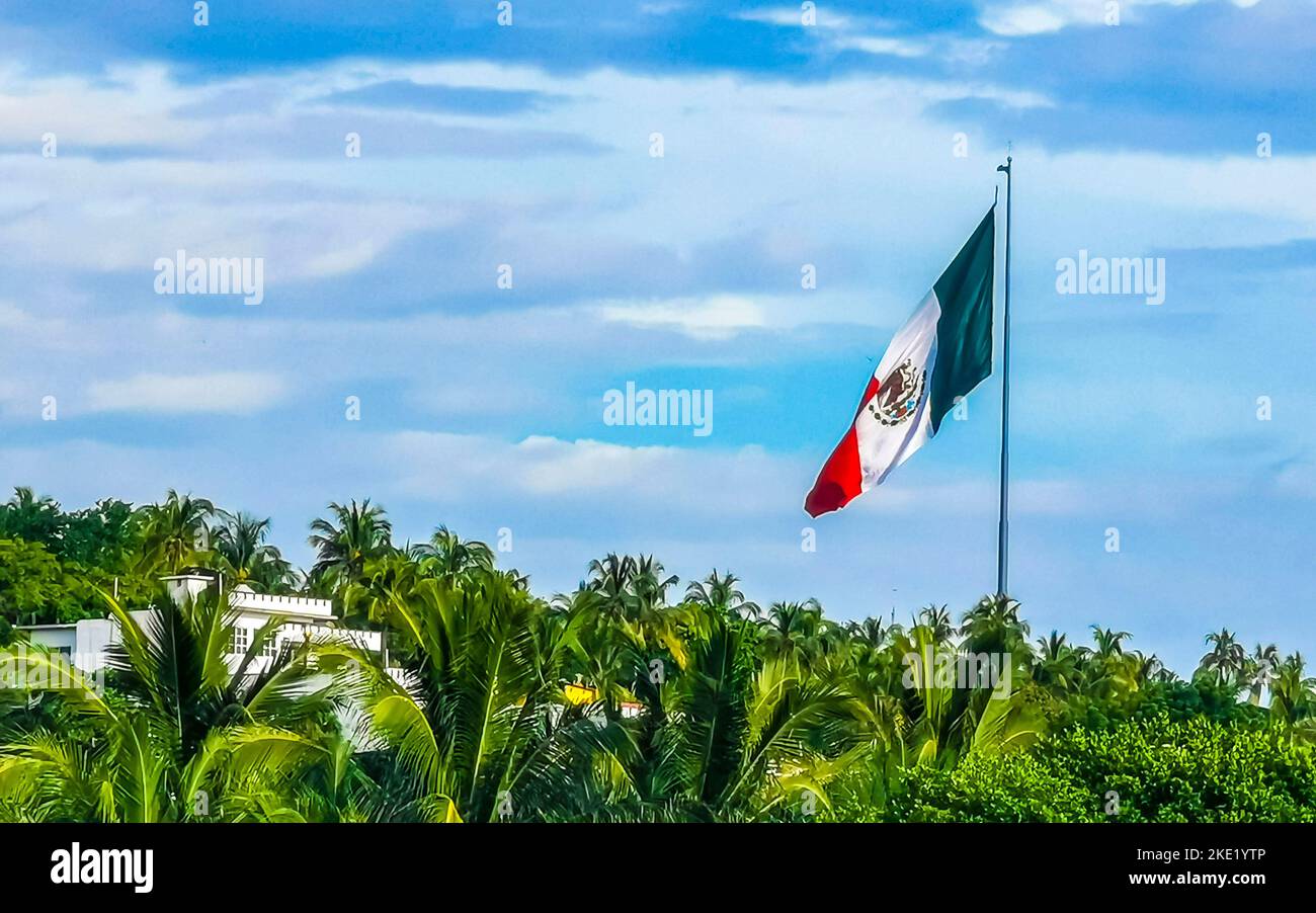 Mexican green white red flag with palm trees and blue sky and clouds in
