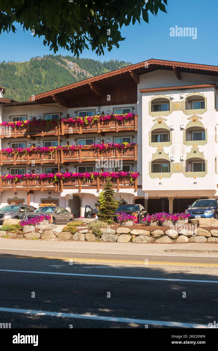 Balconies of a Bavarain style hotel in Leavenworth, Washington, USA overflow with flower boxes of purple petunias. Stock Photo