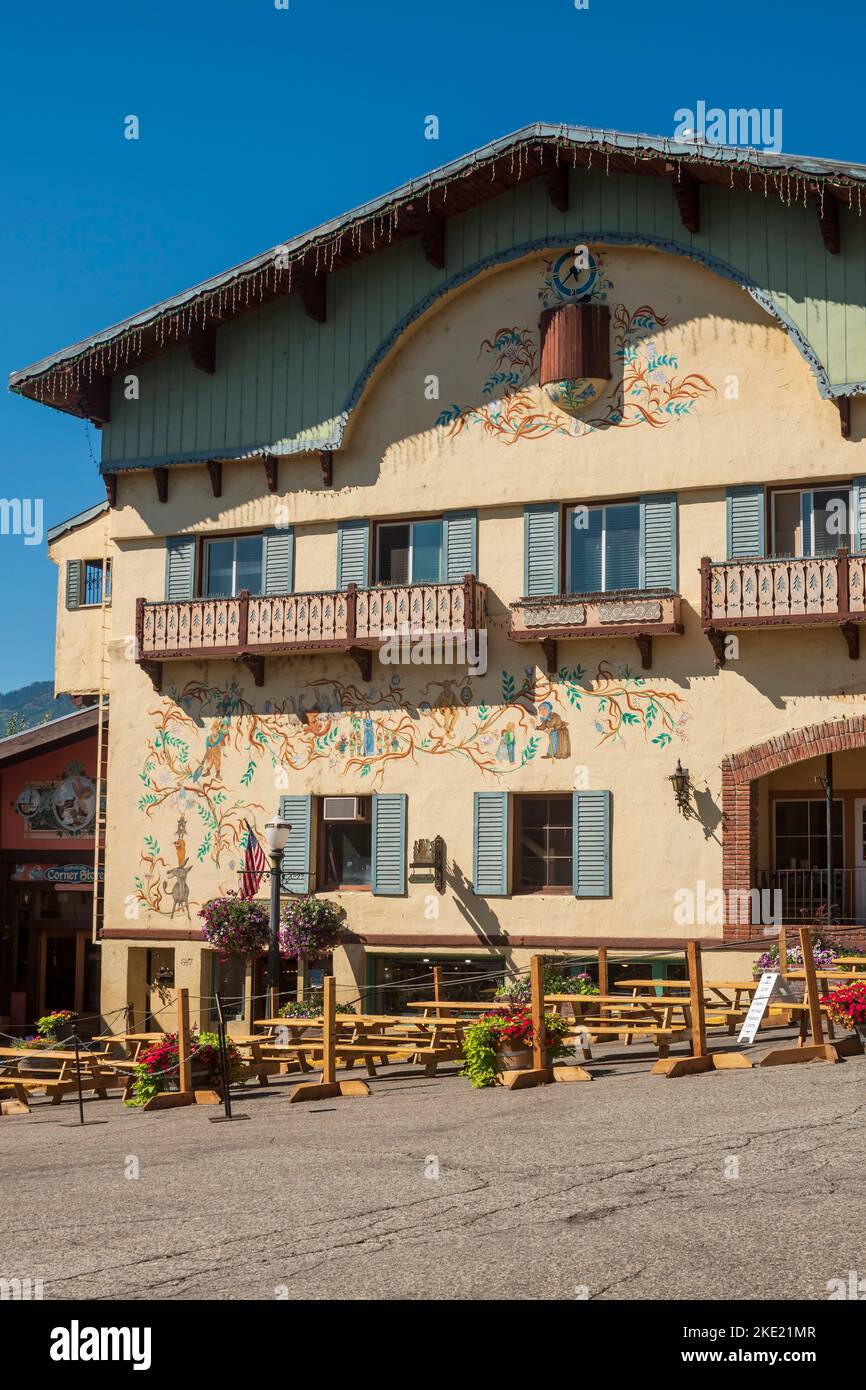 An ornately painted Bavarian style building with outdoor dining tables