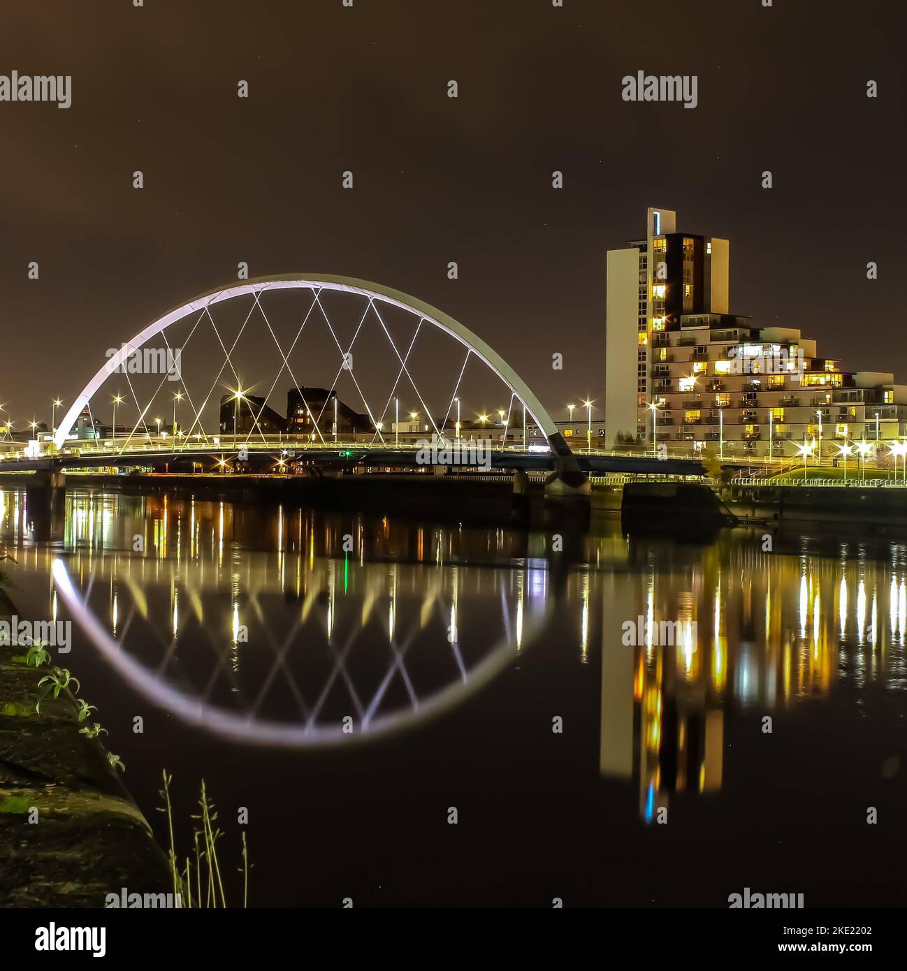 An aerial view of Glasgow surrounded by buildings and water in night