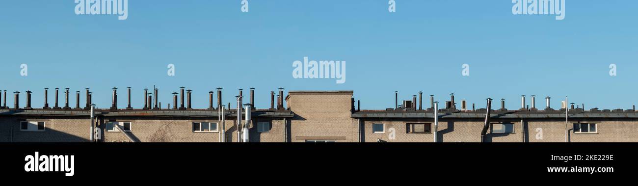 A row of air duct and chimneys on the top of the roof, panoramic view Stock Photo