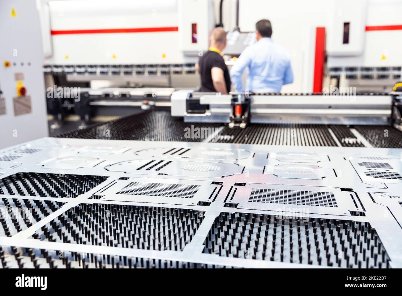 Computer numerical control programmable machine for metal, men working in the background Stock Photo