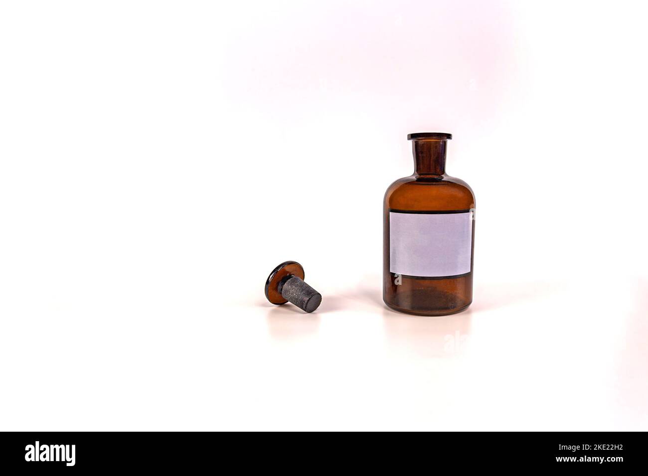 Brown medical jar with a glass stopper on a white background with a