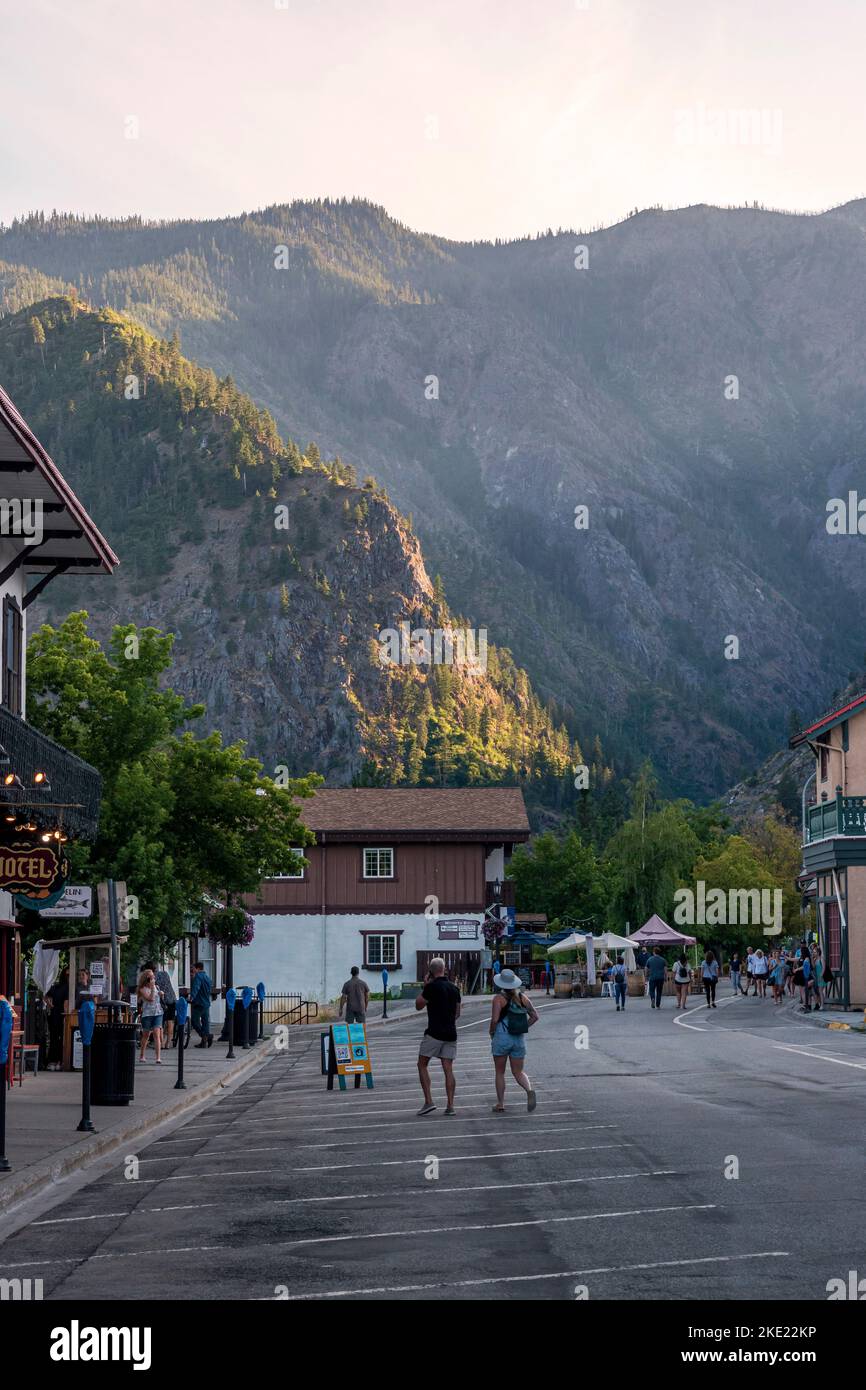 Tourists stroll a pedestrian-only street under the Cascade Mountains in the Bavarian-themed town of Leavenworth, Washington, USA. Stock Photo