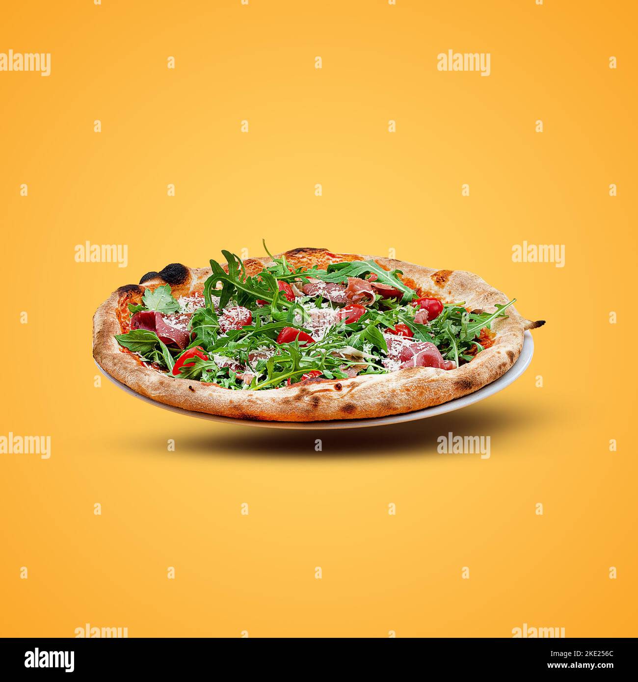 Homemade Italian pizza on a yellow background. Pizza parma. Top view. Stock Photo