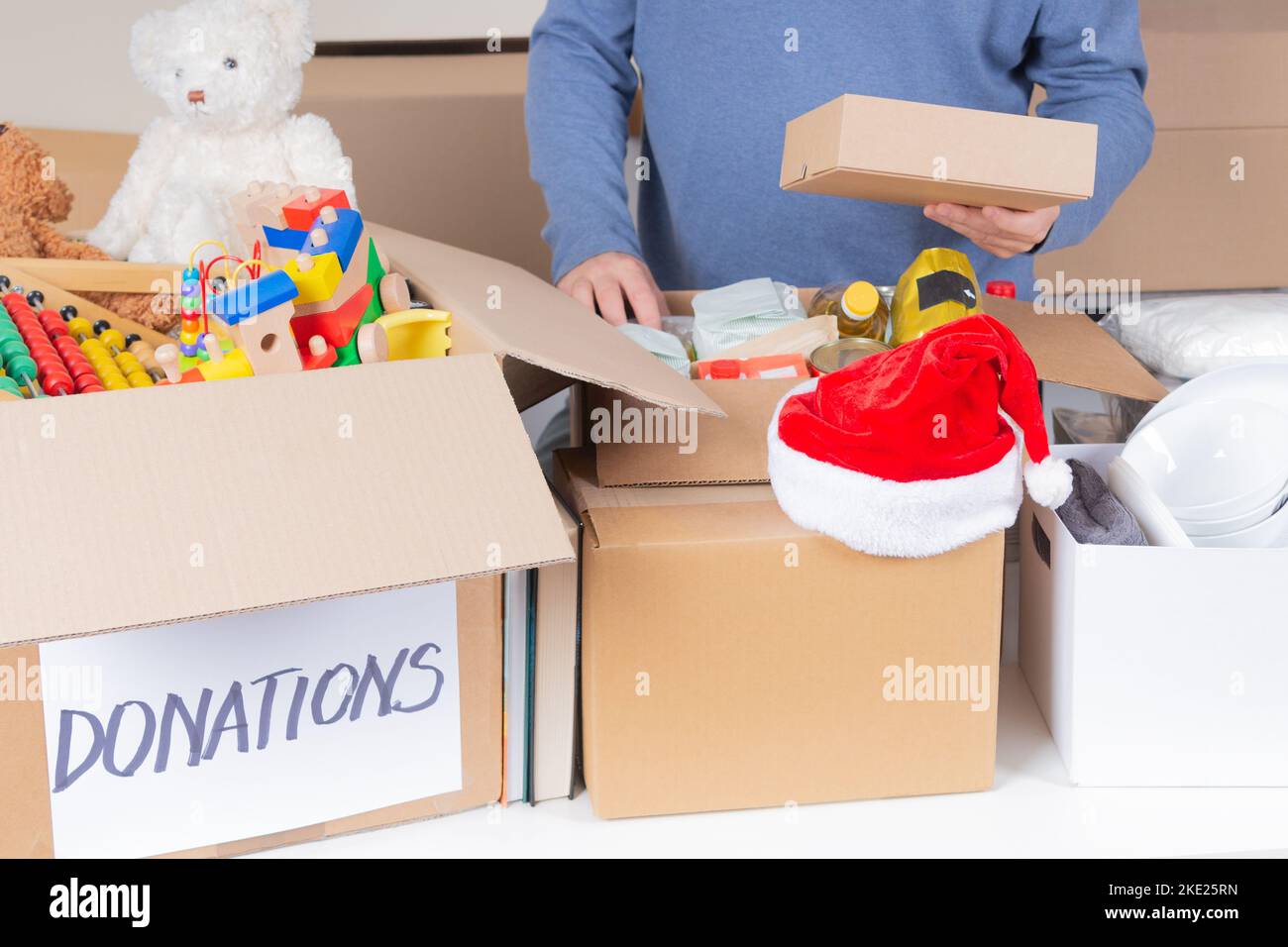 Christmas donations for charity. Man volunteer collecting food, clothes