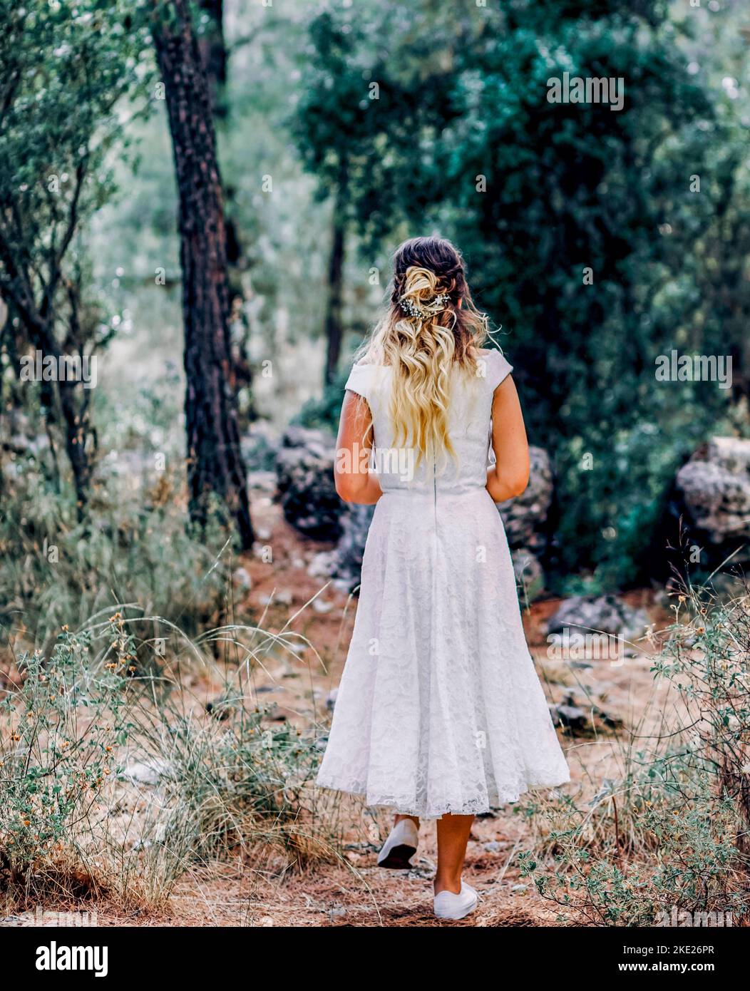 bride in white dress walking alone in the Forest Stock Photo