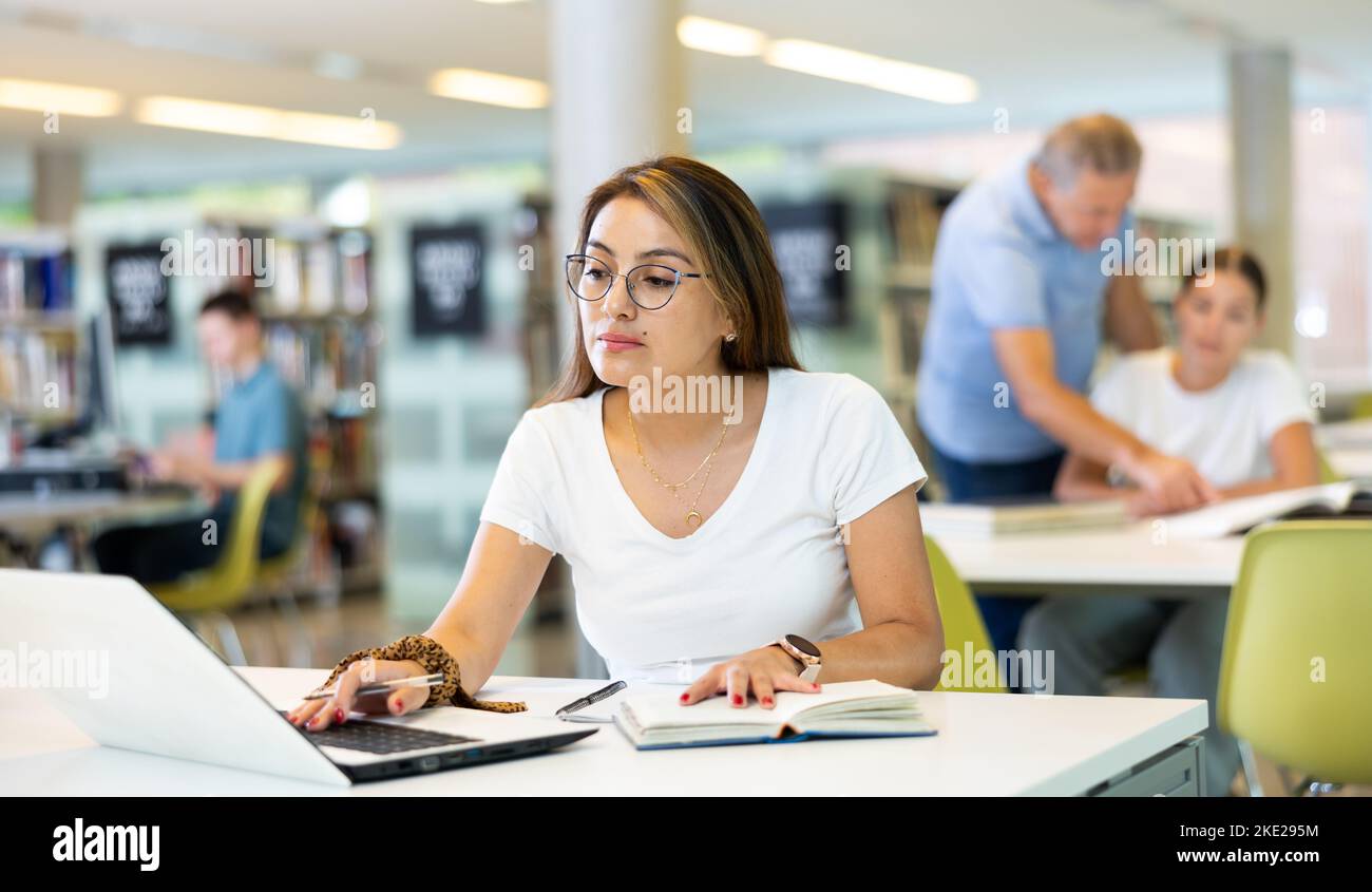 Girl in a library on laptop hi-res stock photography and images - Alamy