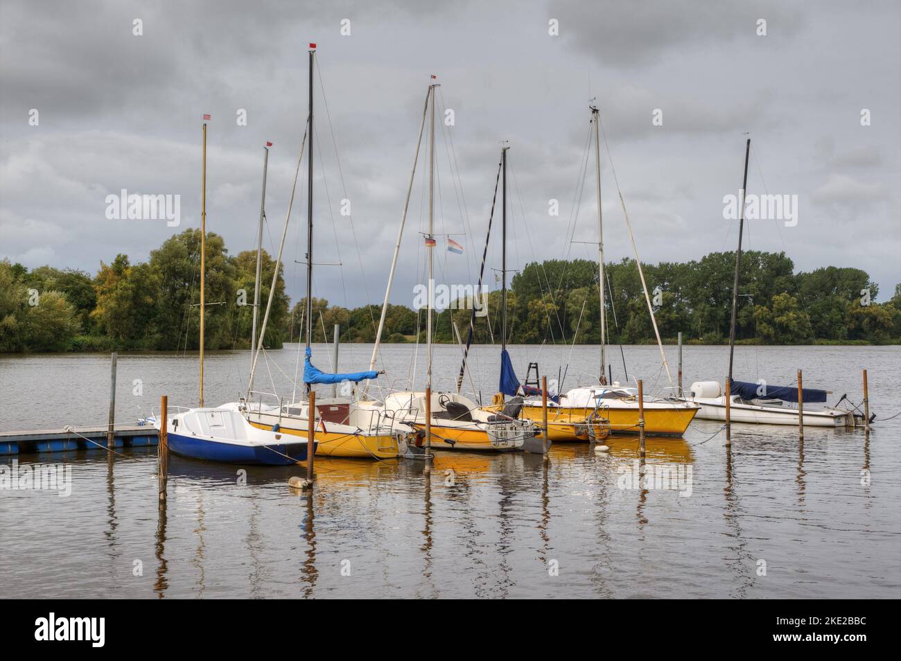 Dark clouds lie over the small jetty at Lake Vörder. The approximately 50 hectare lake offers ideal water sports for surfers and sailors. Stock Photo