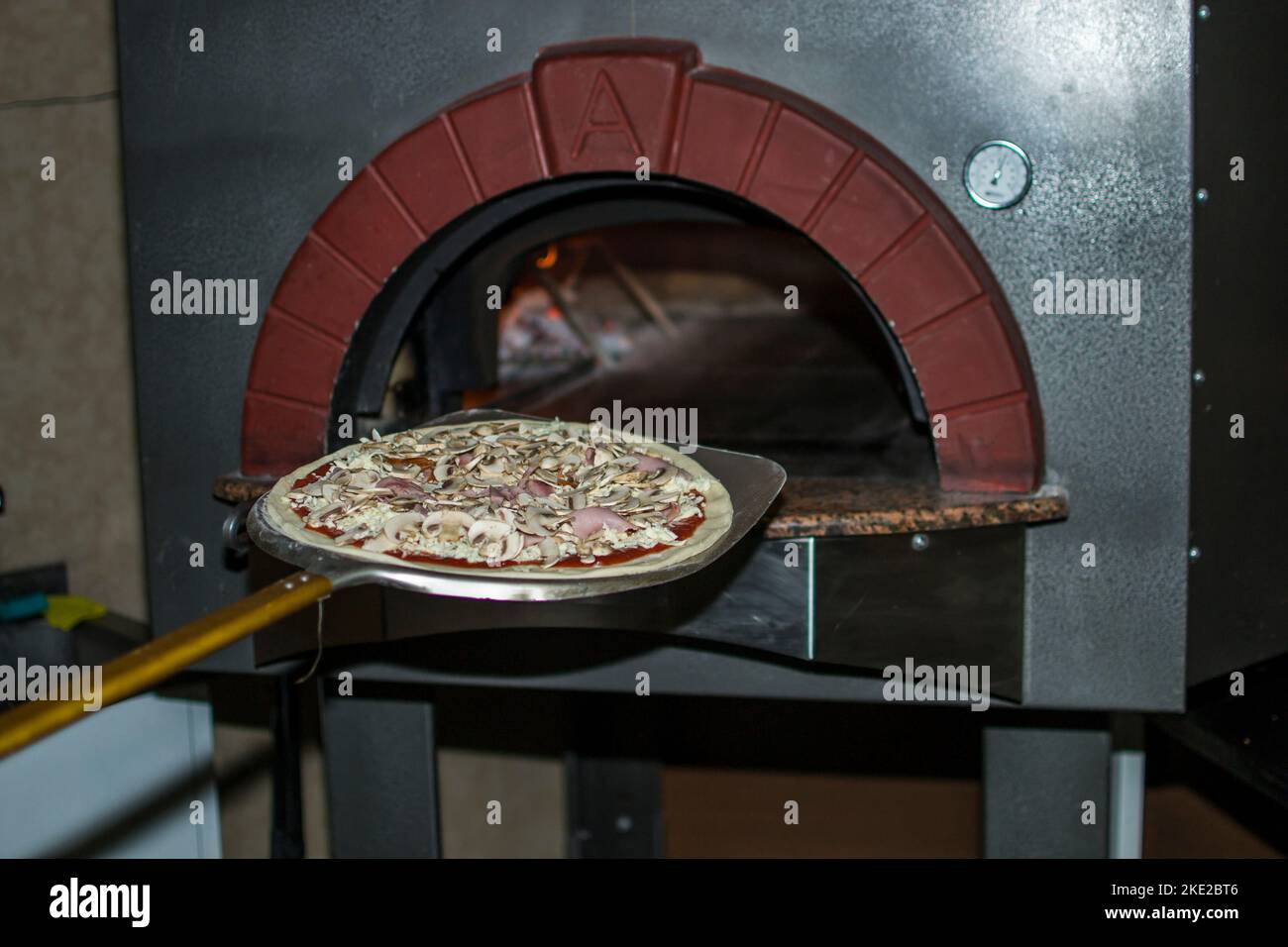 cooking pizza in the oven . Pizza near the stone stove with fire. Background of a traditional